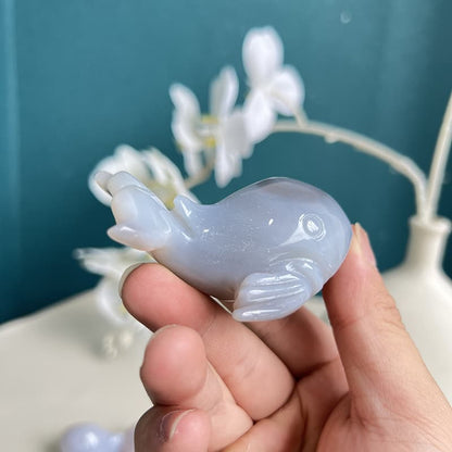 Blue agate whale crystal carving displaying translucency in light