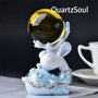 Hand-shaped blue crystal ball stand with elegant silver detailing holding amber sphere