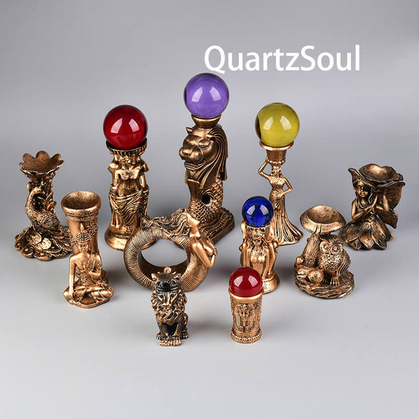 Collection of bronze crystal holders featuring mythological figures and animals for displaying healing stones