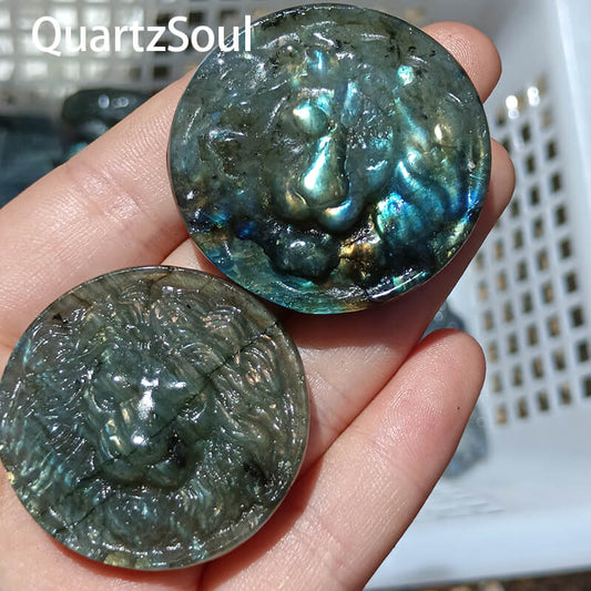 Round blue labradorite crystal with carved lion head displaying vibrant blue flash