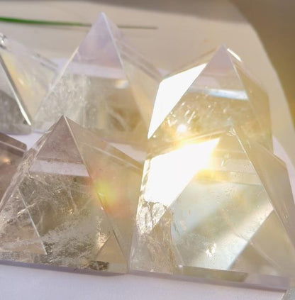 Hand holding a clear quartz pyramid for perspective