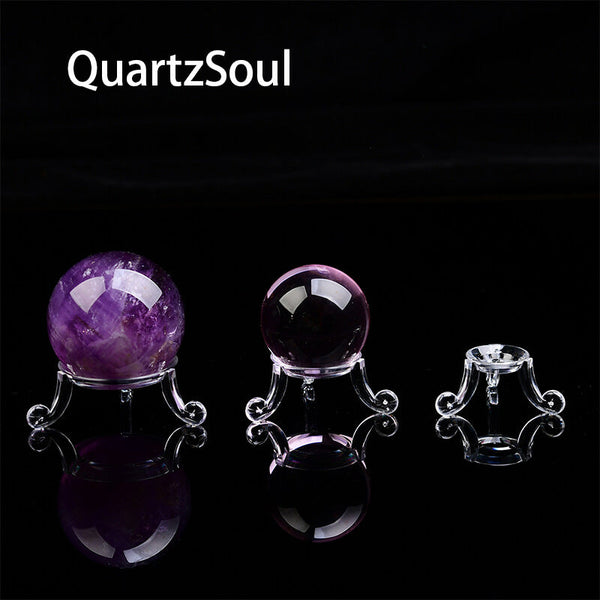 Collection of crystal spheres displayed on clear acrylic stands in various sizes