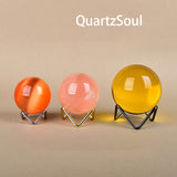 Colorful crystal spheres displayed on elegant wave stands in multiple finishes