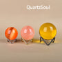 Colorful crystal spheres displayed on elegant wave stands in multiple finishes