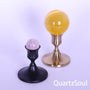 Crystal ball stands in black and gold displaying rose quartz and citrine spheres