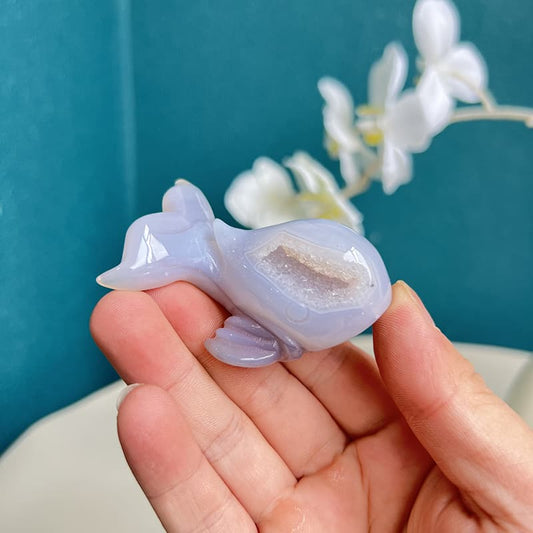 Handcrafted dolphin agate crystal carving with purple hues and geode interior