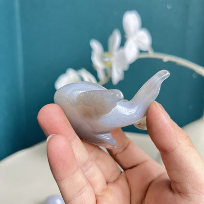 Person holding dolphin agate crystal carving showing scale