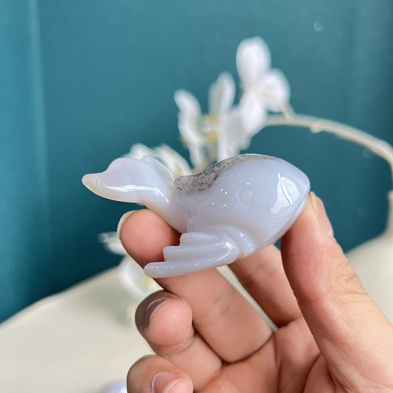 Dolphin agate crystal carving held in palm showing size proportion
