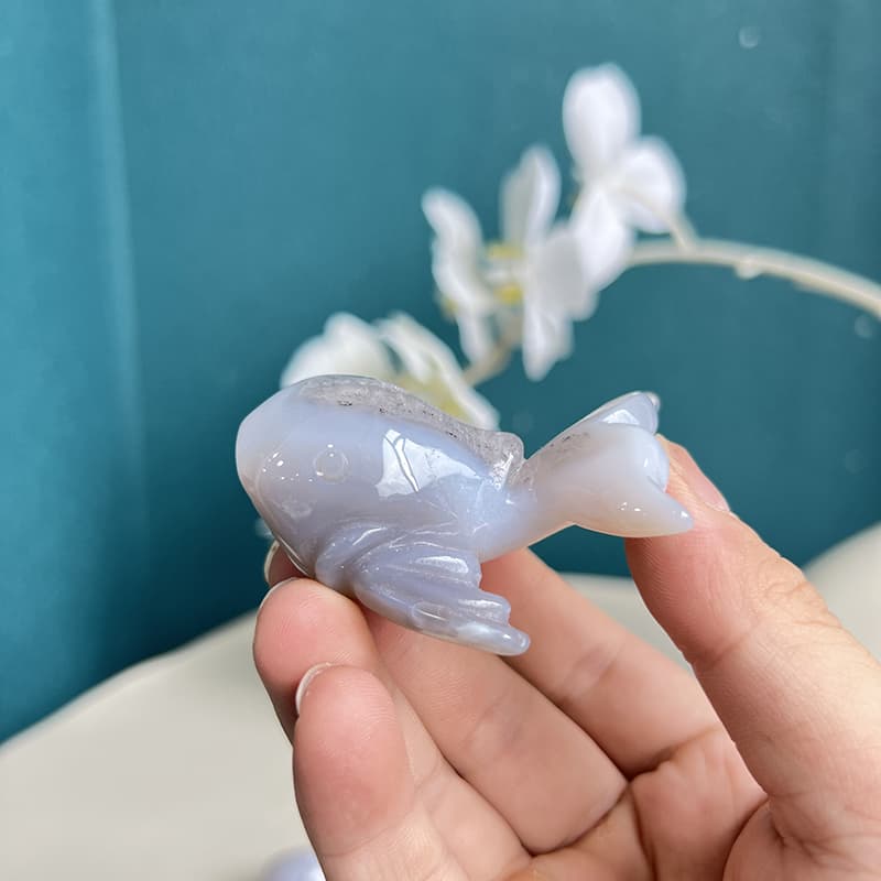 Polished white agate crystal dolphin carving with natural banding patterns