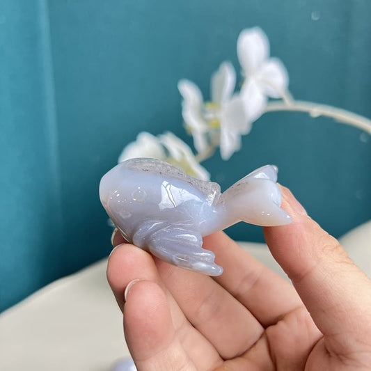 Polished white agate crystal dolphin carving with natural banding patterns
