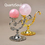 Elegant metal crystal ball stands in gold and silver displaying pink quartz spheres
