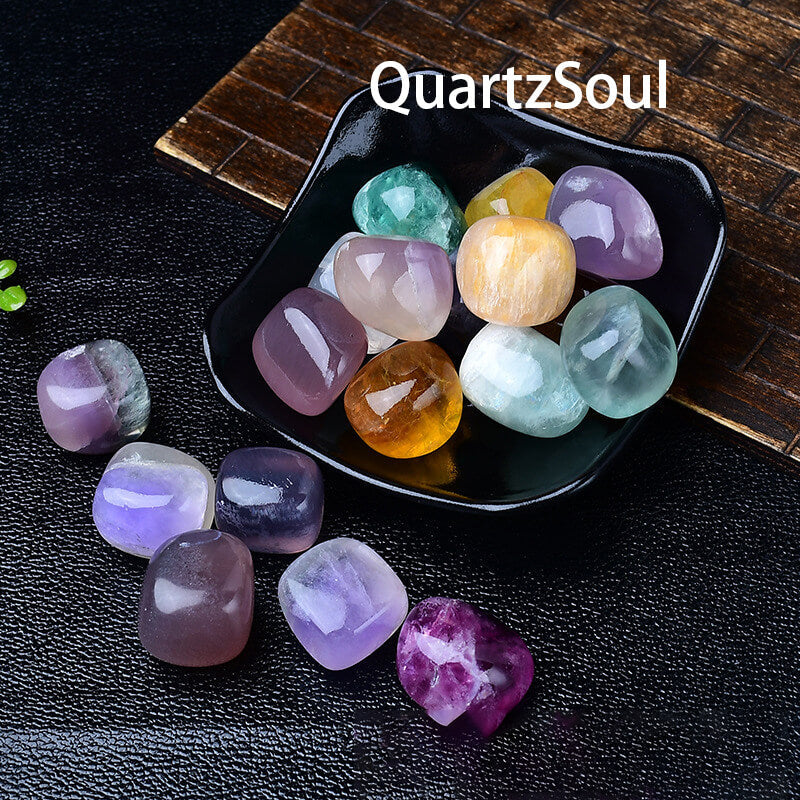 Assorted fluorite tumbled crystals in black display bowl showing vibrant colors