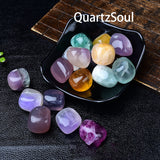 Assorted fluorite tumbled crystals in black display bowl showing vibrant colors