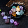 Assorted fluorite tumbled crystals in black display bowl showing vibrant colors