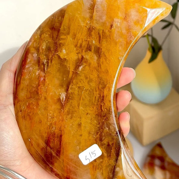 Golden Healer Moon Crystal displayed on wooden stand showing healing properties