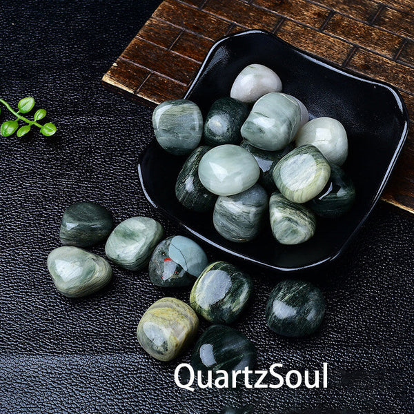 Green Rutilated Quartz tumbled stones displayed in a decorative bowl showing size and texture