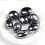 Natural Hematite tumbled stones with metallic silver-gray luster displayed on white plate