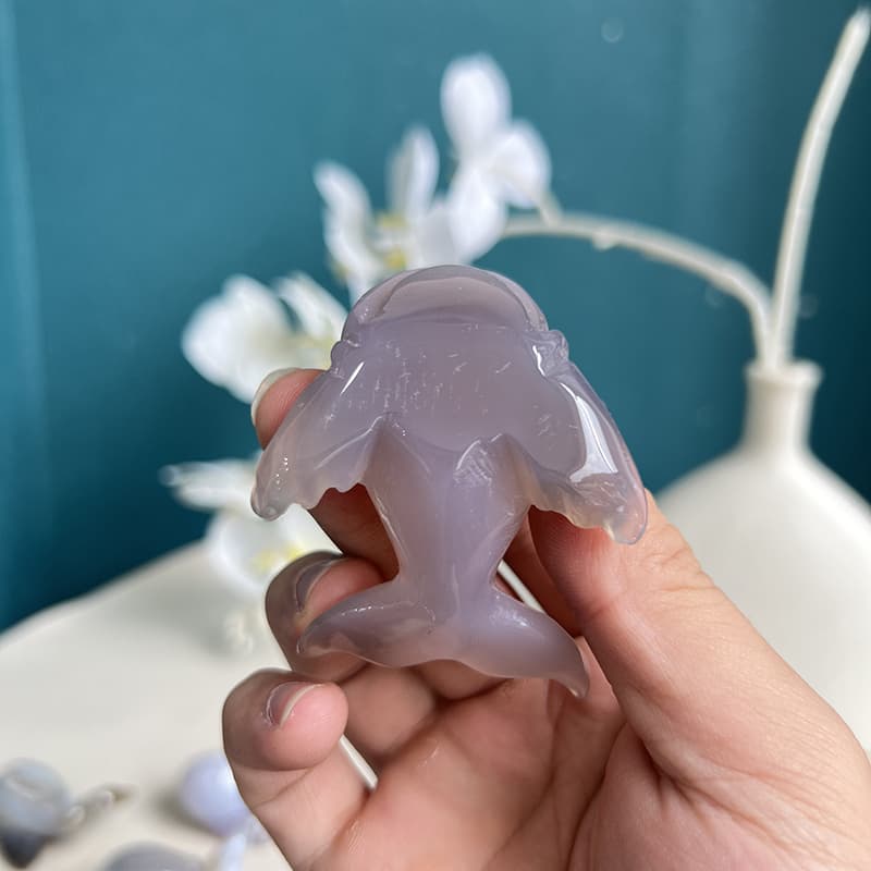 Translucent agate dolphin crystal carving illuminated to show inner patterns and clarity