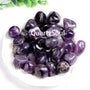 Premium natural amethyst tumbled stones collection in white bowl showing purple crystal variations