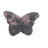 Rhodonite butterfly carving displayed with complementary healing crystals