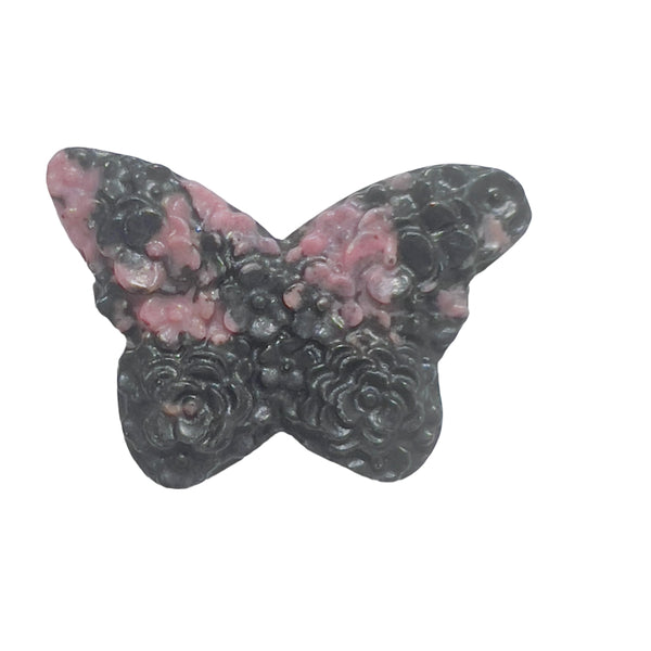 Rhodonite butterfly carving displayed with complementary healing crystals