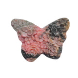 Butterfly rhodonite crystal as centerpiece in spiritual altar arrangement