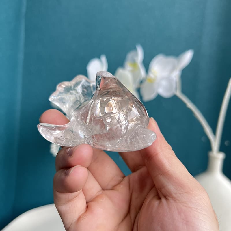 Side profile of transparent quartz dolphin carving showing fine details