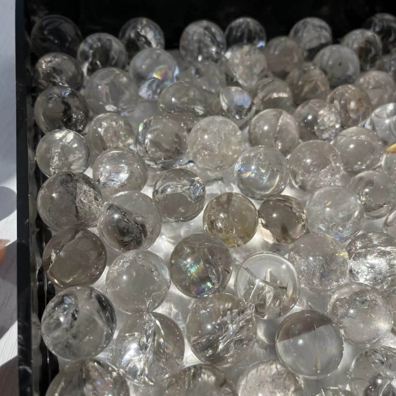 Mini clear quartz sphere displaying rainbow light reflections