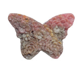 Rhodonite butterfly crystal positioned for heart chakra healing practice