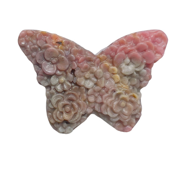 Rhodonite butterfly crystal positioned for heart chakra healing practice