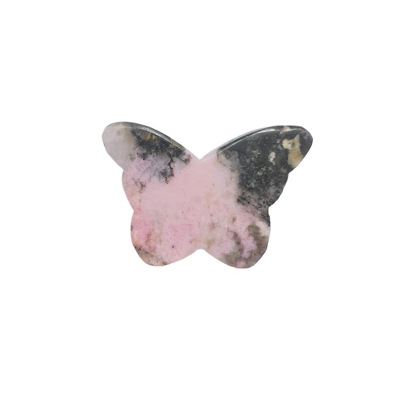 Rhodonite butterfly in metaphysical altar setting with candles and herbs