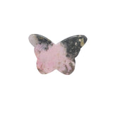 Rhodonite butterfly in metaphysical altar setting with candles and herbs