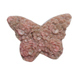 Rhodonite butterfly carving shown in palm for size perspective