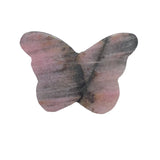 Pink rhodonite butterfly crystal sculpture displayed on wooden stand