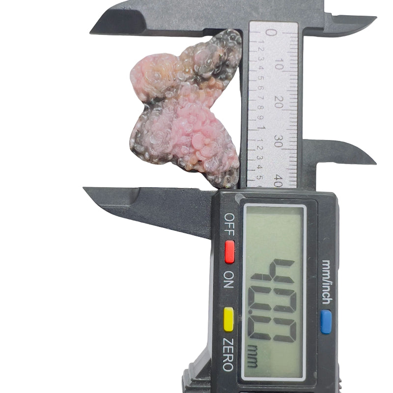 Pink rhodonite butterfly crystal sculpture displayed