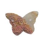 Close-up of intricate rose carvings on pink rhodonite butterfly crystal