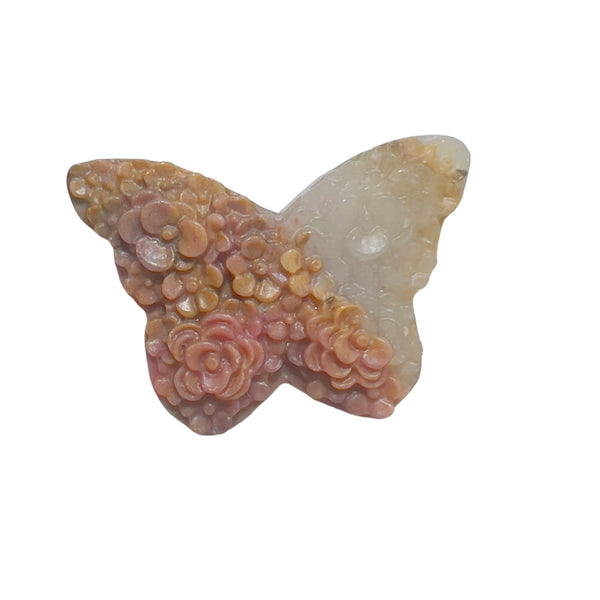 Close-up of intricate rose carvings on pink rhodonite butterfly crystal