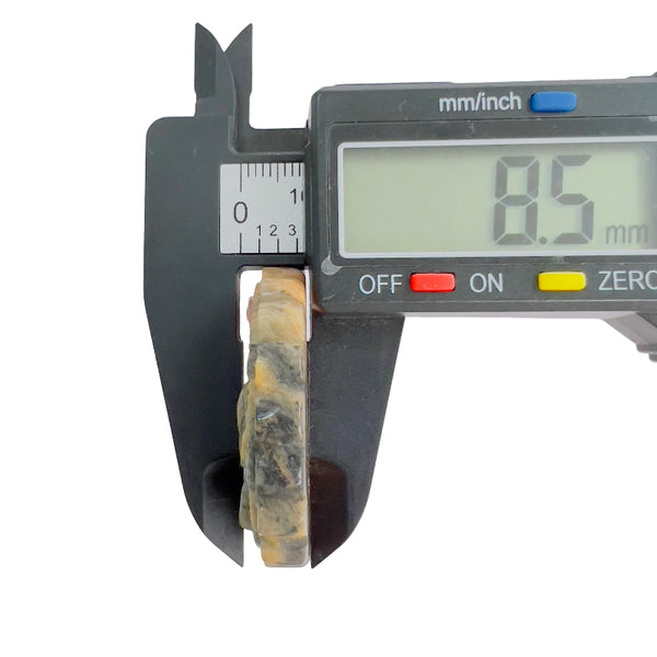 Thickness measurement of rhodonite crystal carving showing detailed layering