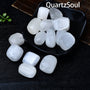 Selenite tumbled stones in black dish showing smooth polished surfaces and natural luminosity