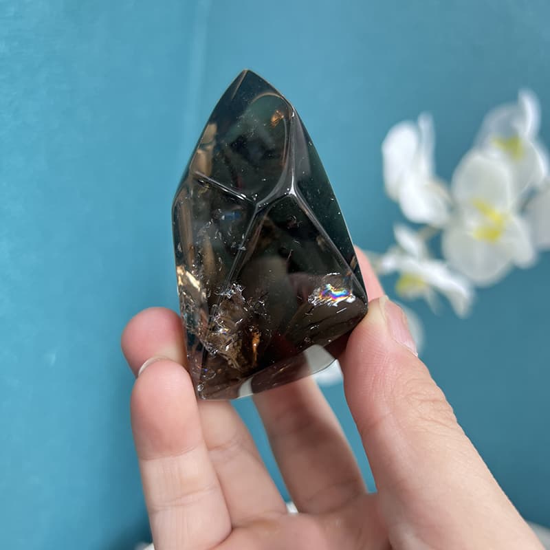 Smoky quartz free form crystal with white orchid showing spiritual home decor use