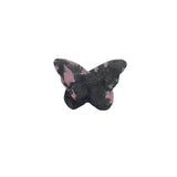 Rhodonite butterfly crystal carving displayed on altar setting for spiritual healing