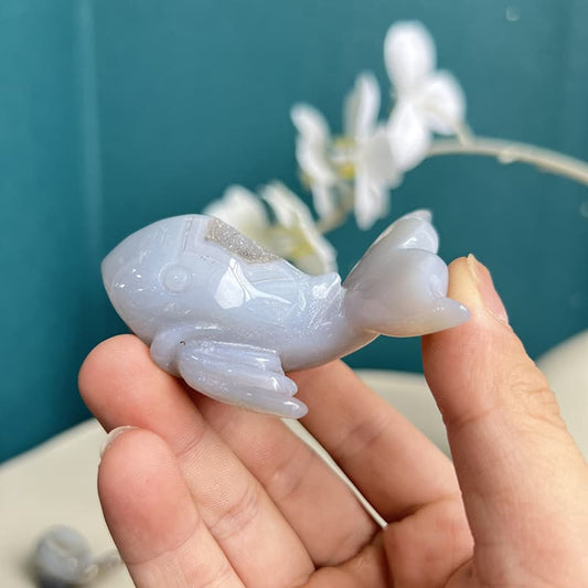Handcrafted white agate crystal dolphin carving on display
