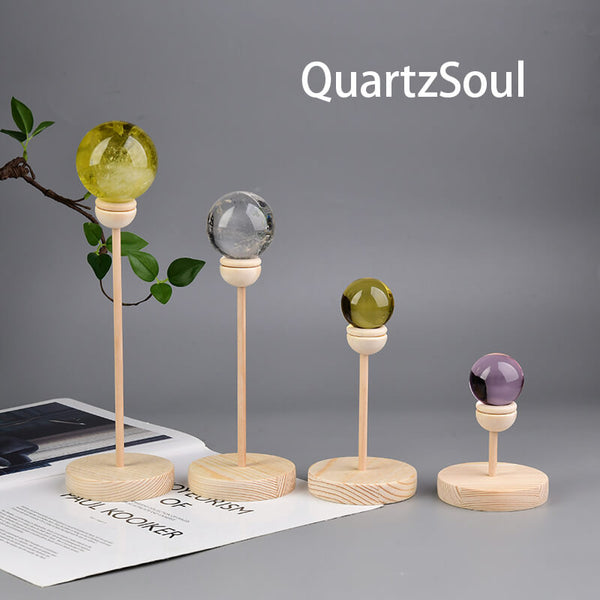 Handcrafted wooden crystal ball stands in various heights with colorful crystal spheres