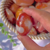 Natural Carnelian Palm Stone shown in hand for size reference