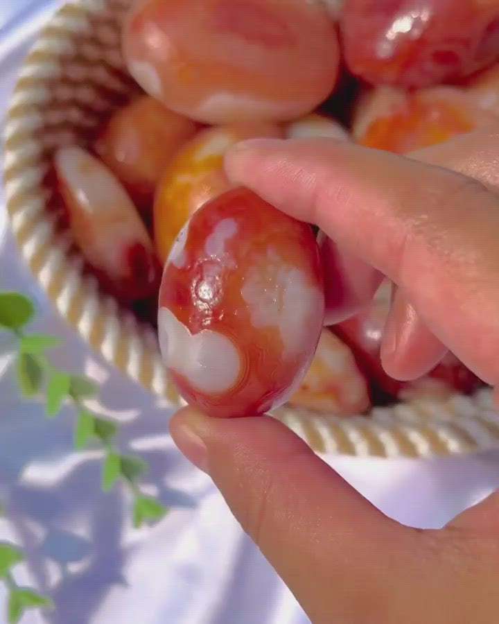 Natural Carnelian Palm Stone shown in hand for size reference