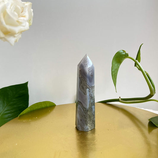 Natural moss agate tower crystal with forest-like patterns on gold display