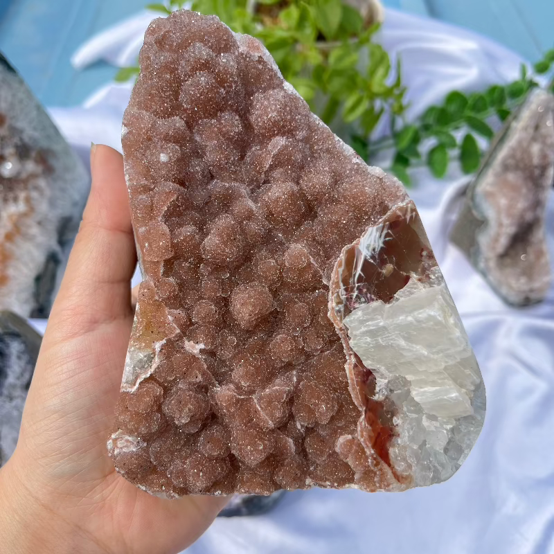 Hand holding natural sugar druzy crystal showing size perspective