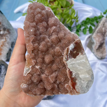 Hand holding natural sugar druzy crystal showing size perspective